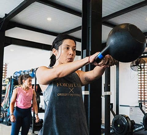 female gym members exercising with kettlebell