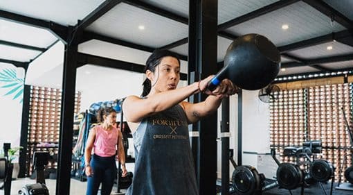 female gym members exercising with kettlebell